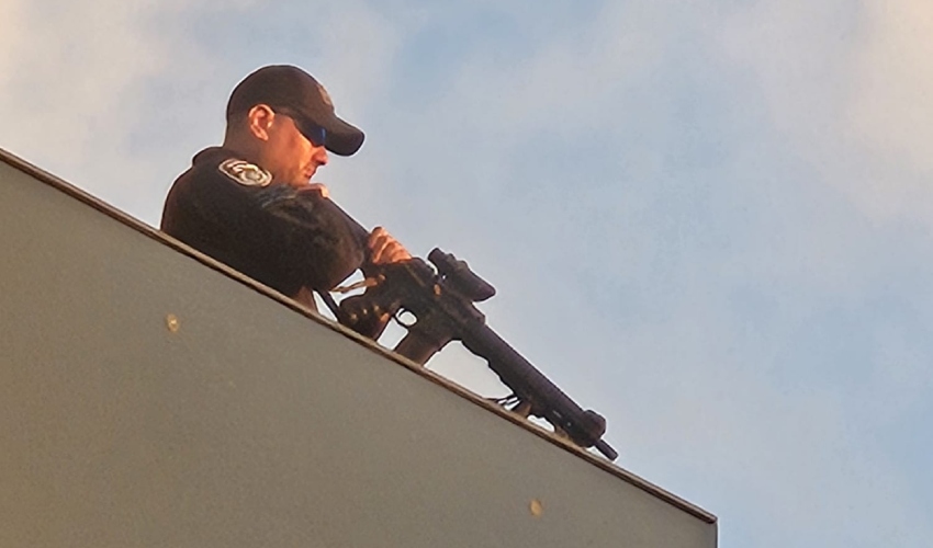 שוטר על גג מרכז חורב עם נשק מופנה לעבר המפגינים (צילום: מחאת העם)